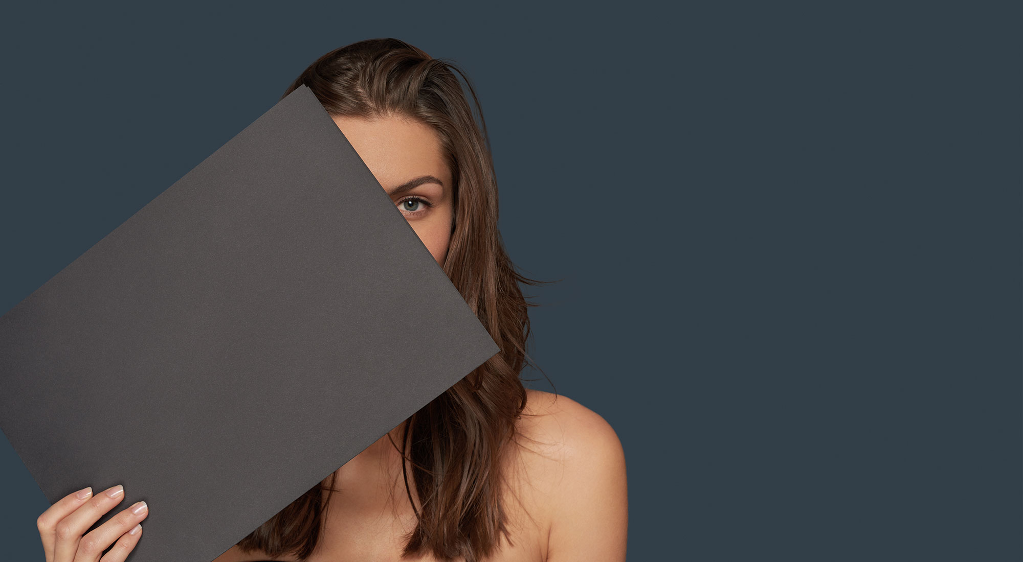 amiea model holding a grey piece of paper on a dark grey background