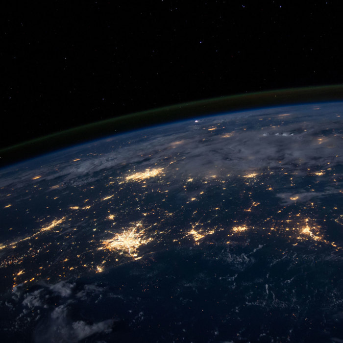 Ansicht der Weltkugel bei Nacht mit sich verbindenden Lichtern zur Darstellung des internationalen Partnernetzwerks von amiea