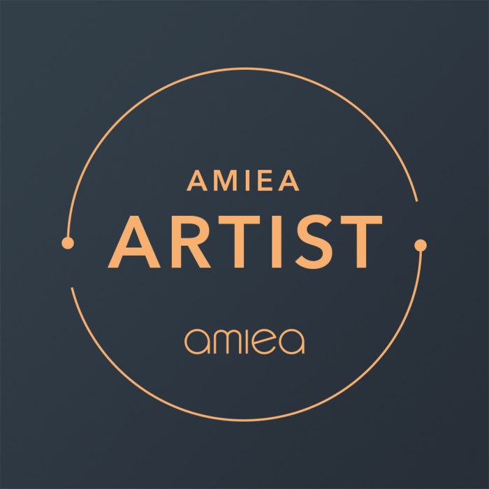 level1-amiea-artist pfirsichfarbenes Signet des amiea-Academy-Artist-Levels auf dunklem Hintergrund