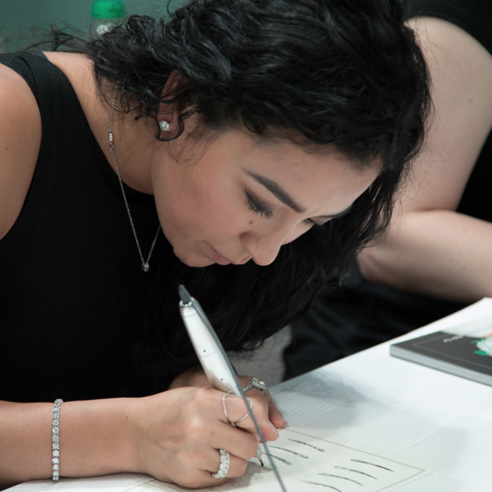 Woman using an amiea device on latex in amiea academy course