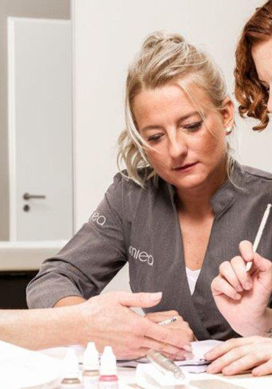 Amiea Academy Kurs Foto von Schuelerinnen, die Informationsmaterial über PMU im Kurs der amiea Academy betrachten